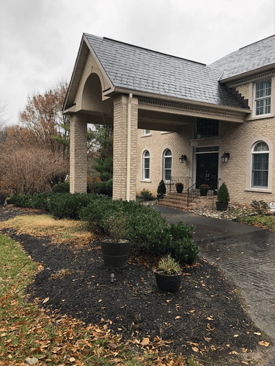 Neatly mulched planting beds around a home's front entrance