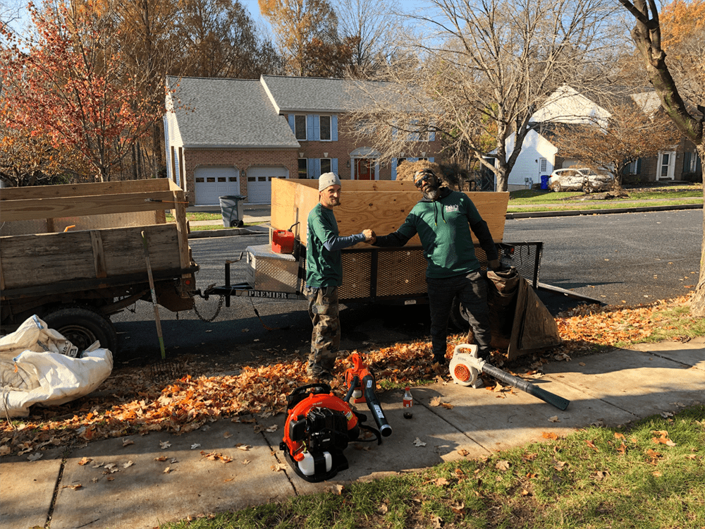 Landscaping crew beside a truck with cleanup equipment