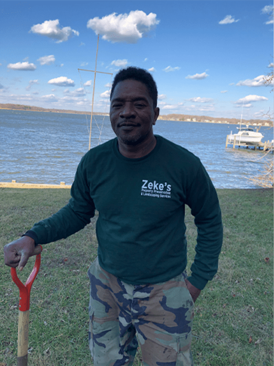 Zeke’s PP Landscaping team member wearing a green work shirt outdoors